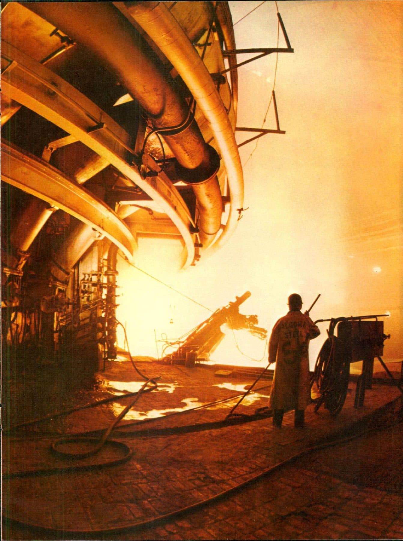 A worker at the glowing open-hearth.