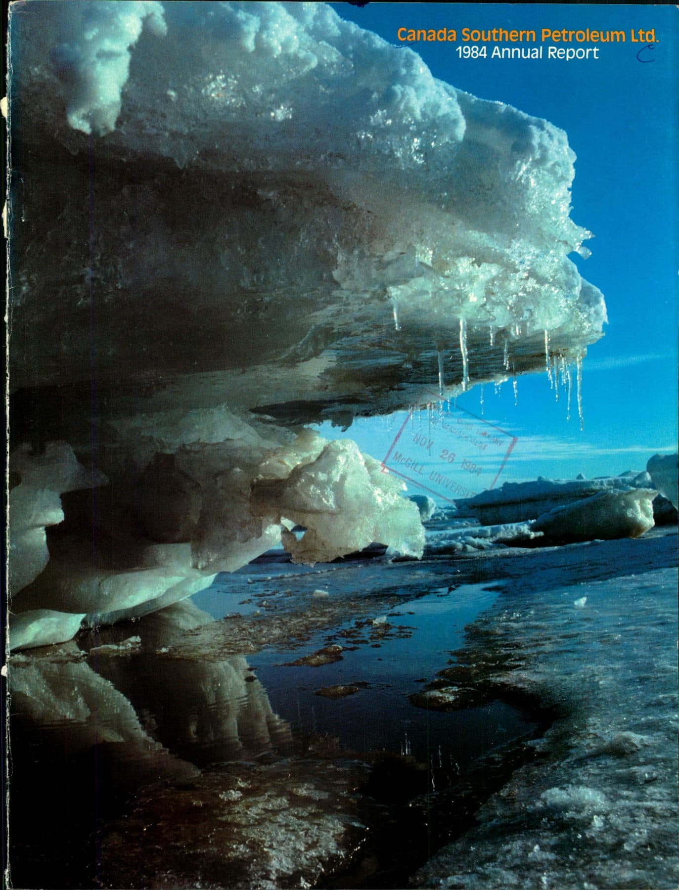 A jagged ice shelf and hanging icicles reflected in a dark Arctic pool under a hard blue sky.