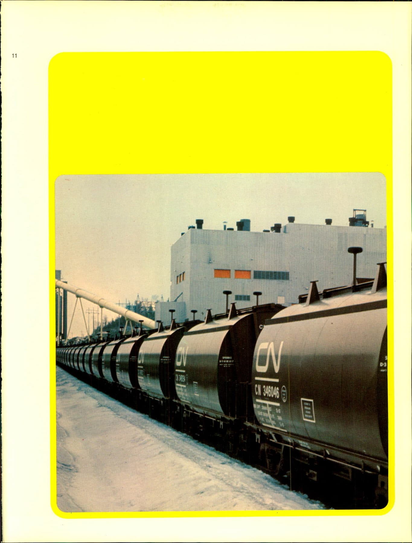 A receding line of black CN tank cars, including CN 346046, in snow beside a plant.