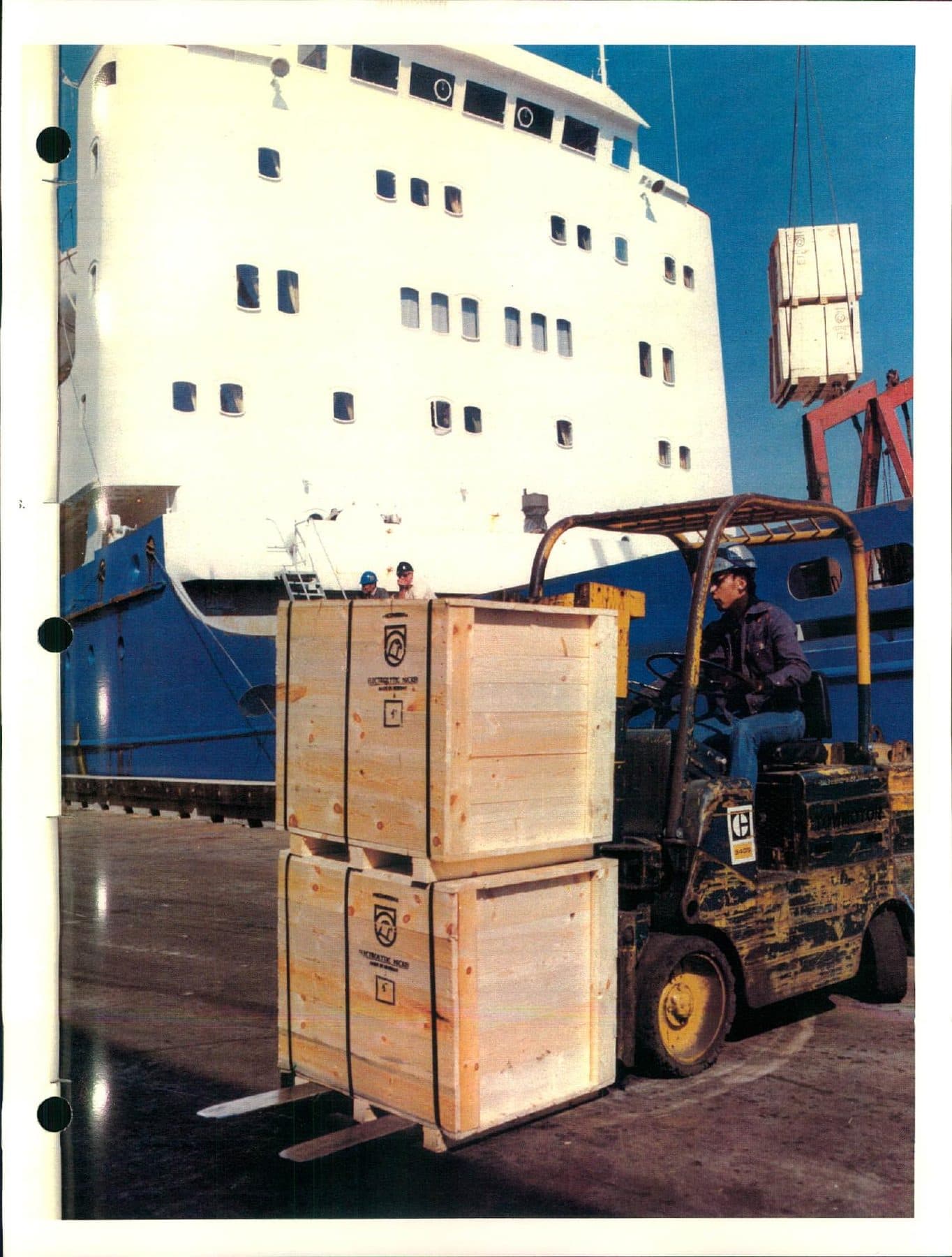 Forklift and crates beside a freighter at the dock.