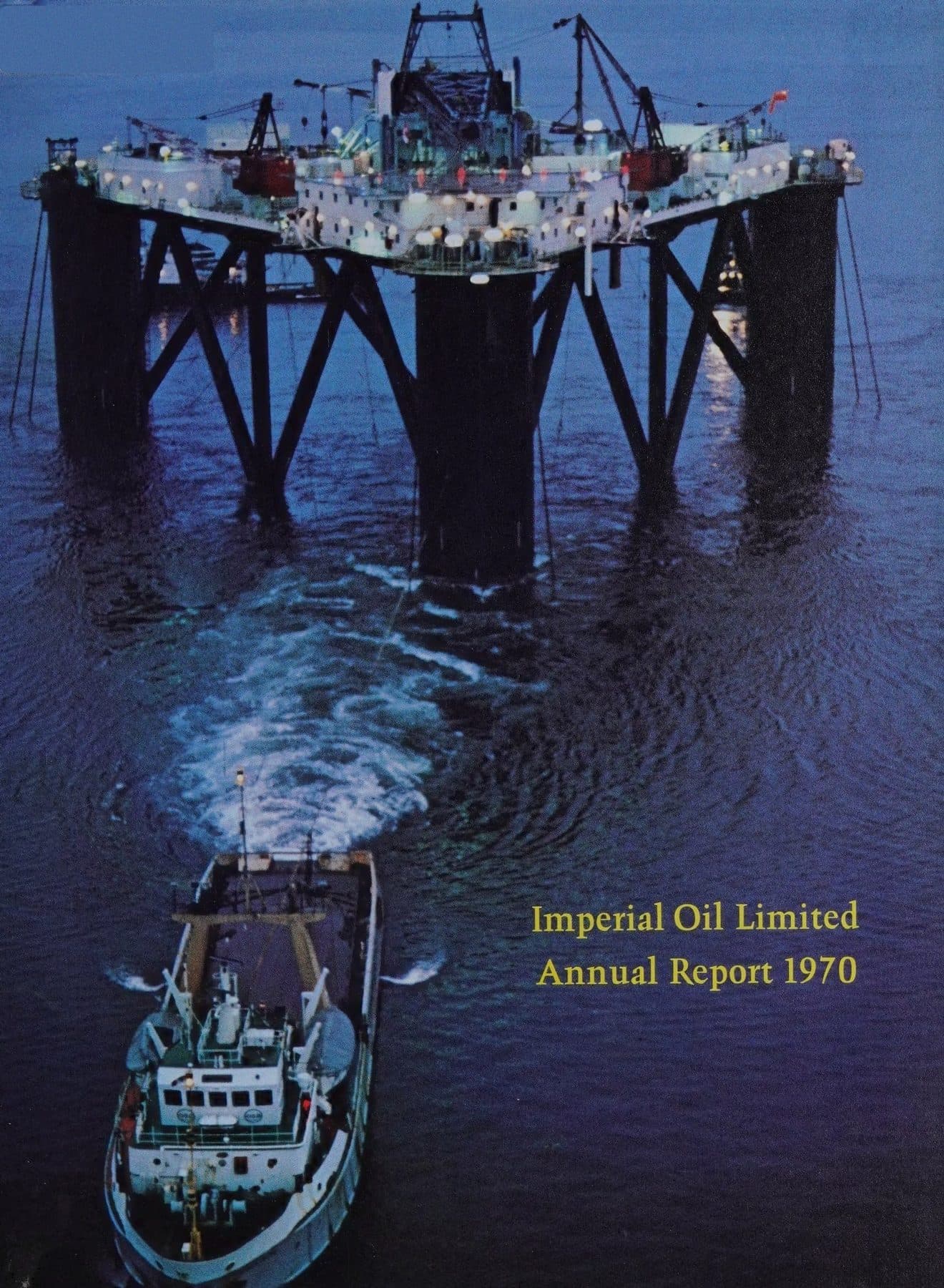 Offshore platform at dusk, supply boat cutting a wake.