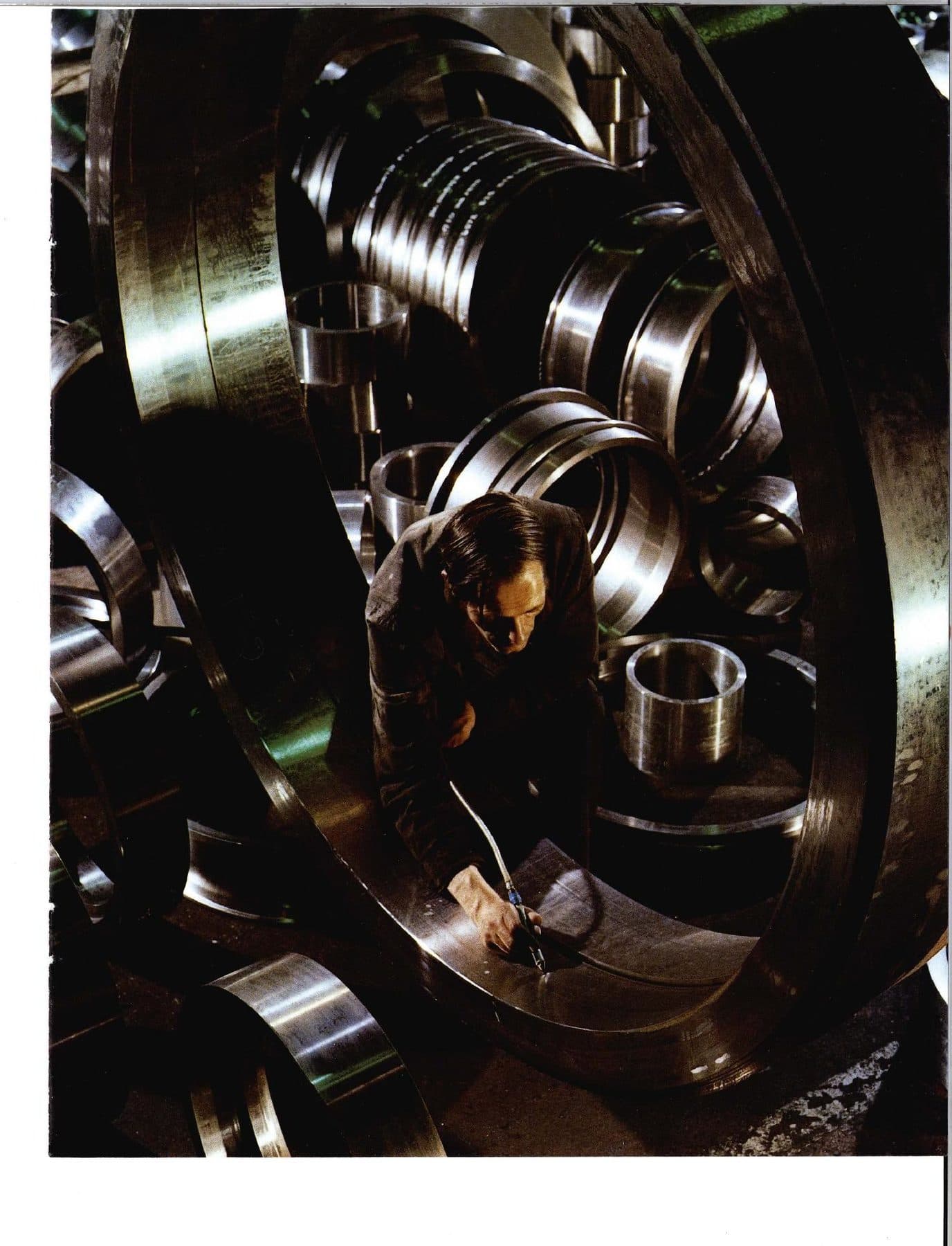 A worker inspecting nested steel rings.
