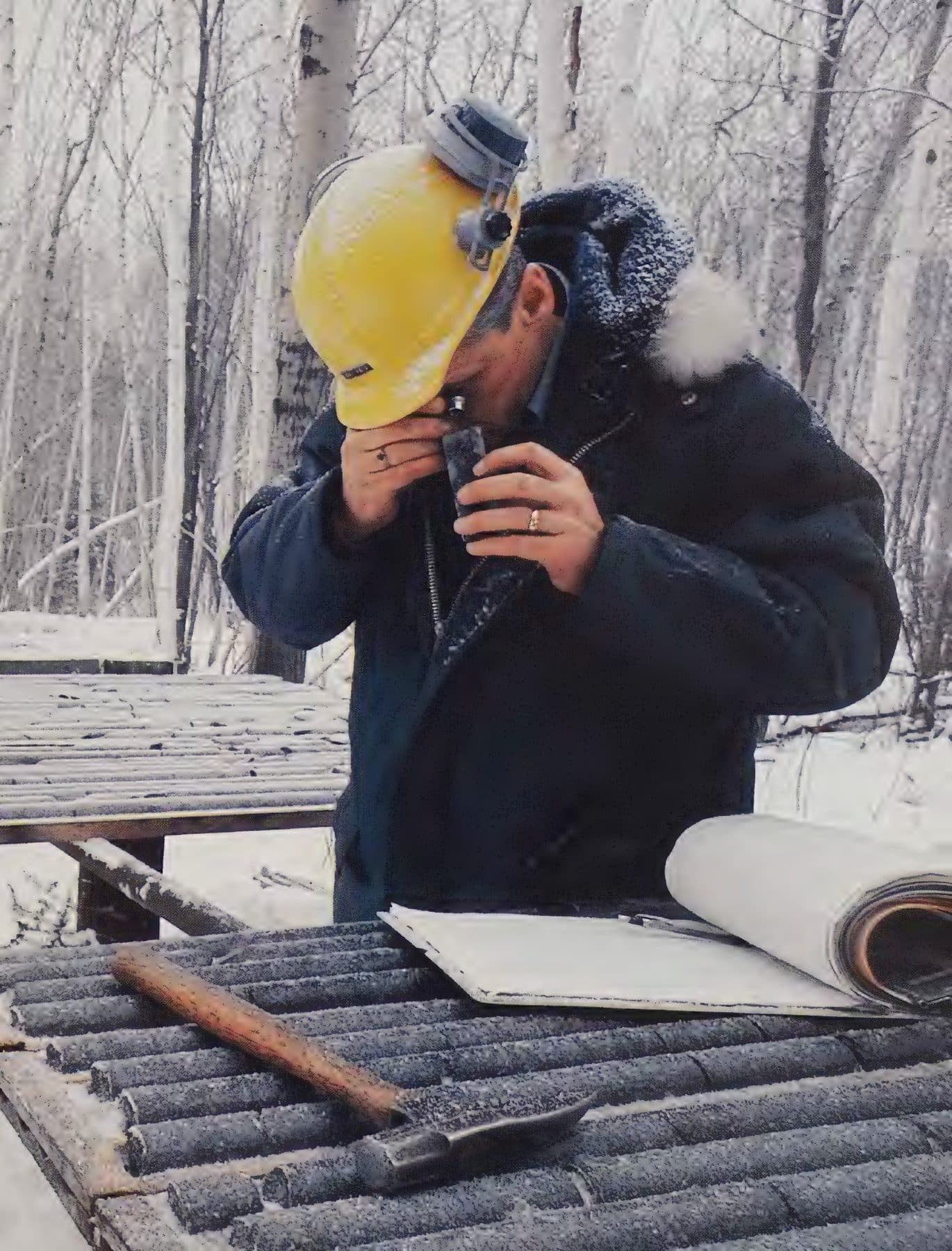 A geologist reading core at a snowy table.