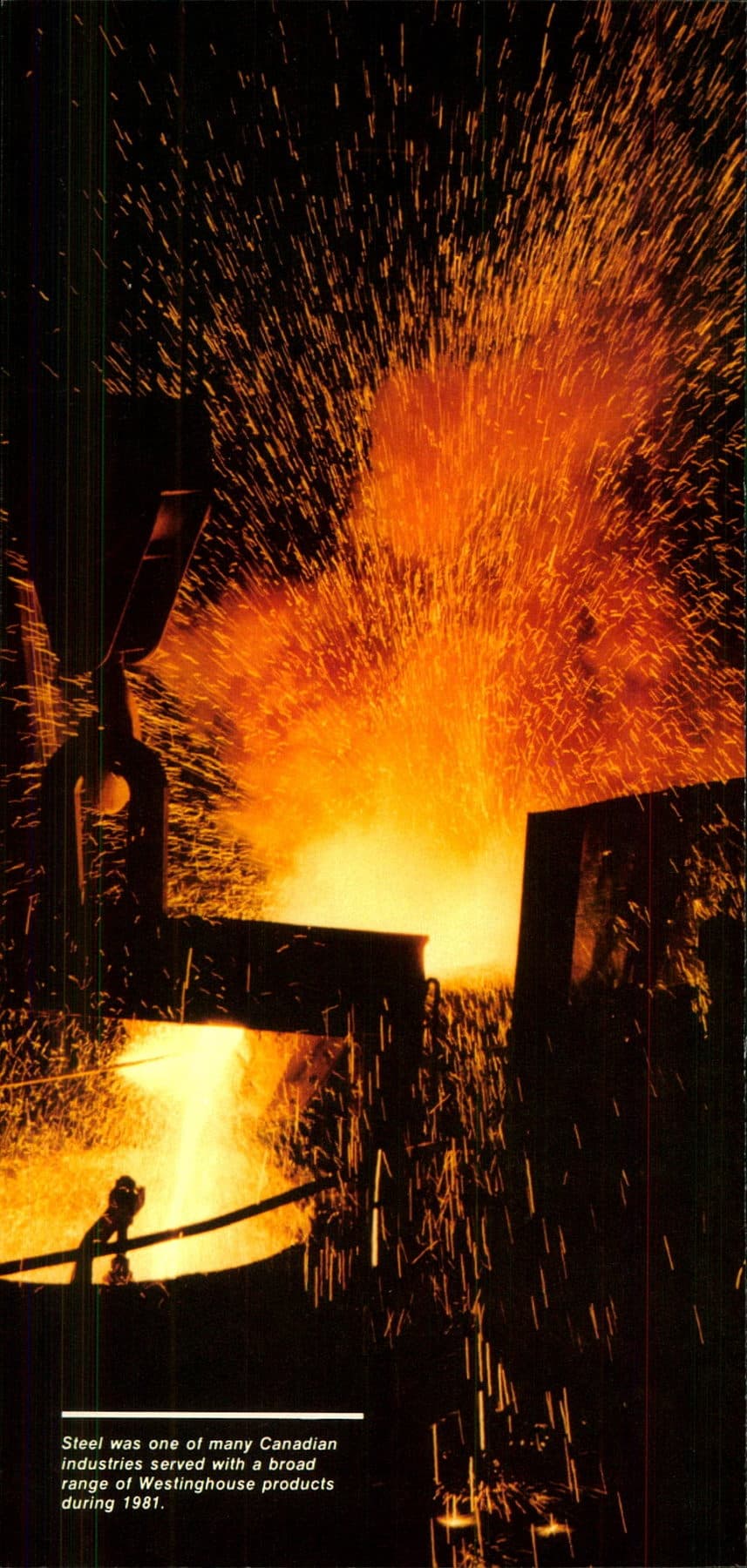 A ladle of molten metal and a shower of orange sparks in a dark mill.